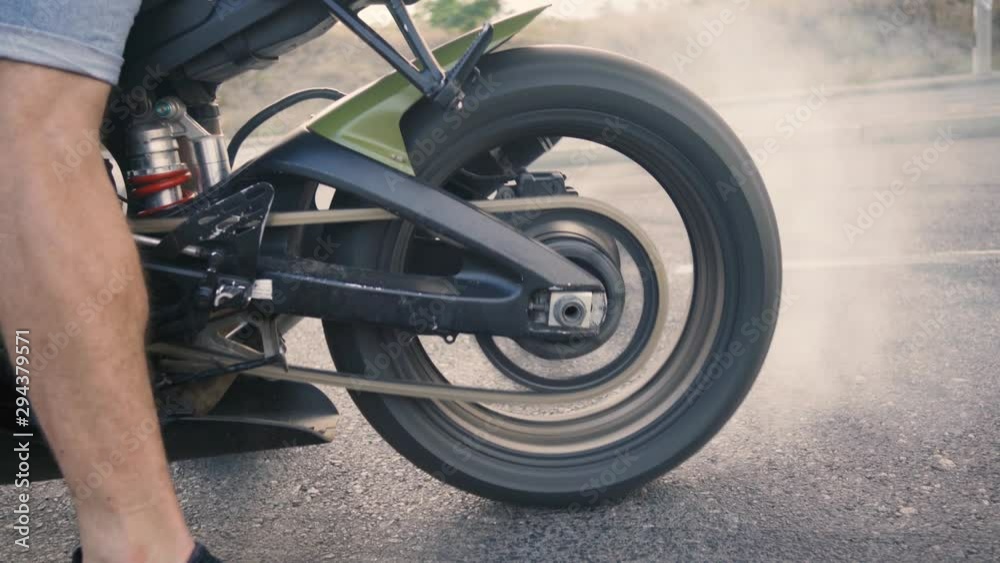 Motorcyclist doing tire burnout on a custom motorcycle, slow motion. Professional motorcyclist drift and turns on a motorcycle on the asphalt, a biker does a trick Motorcyclist doing tire burnout on a custom motorcycle, slow motion. Professional motorcyclist drift and turns on a motorcycle on the asphalt, a biker does a trick