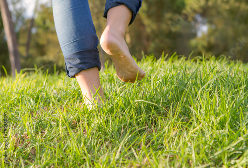 feet onm green grass walking. Selective focus