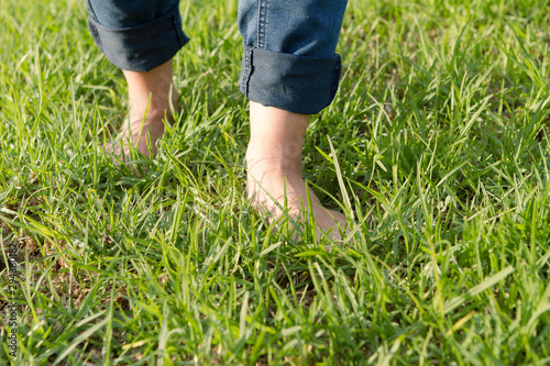 feet on green grass walking. Selective focus
