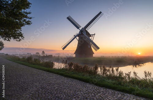 Windmill during a foggy, autumn sunrise in the Dutch countryside. Krimstermolen, Zuidwolde.