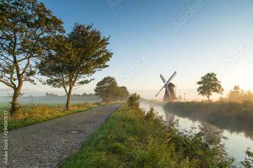 Windmill during a foggy, autumn sunrise in the Dutch countryside. Krimstermolen, Zuidwolde.