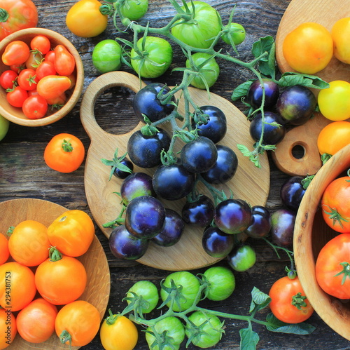 Freshly picked heirloom tomato harvest: pear shaped, beef heart, tigerella, brandywine, cherry, black, indigo rose, green. Organic produce at a Farmer's market photo