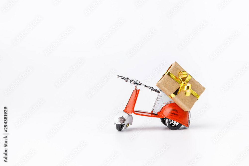 Miniature toy red and white retro scooter with gift on white background. Metal model. Miniature toy red and white retro scooter with gift on white background. Metal model.