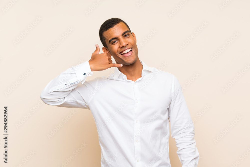 Young handsome brunette man over isolated background making phone gesture. Call me back sign Young handsome brunette man over isolated background making phone gesture. Call me back sign