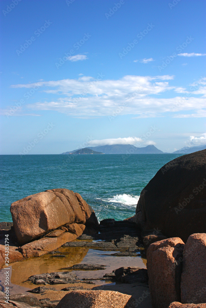 JOAQUINA BEACH, FLORIANOPOLIS, SANTA CATARINA, BRAZIL. View of the rocks in the coast and the sea at background. Stones in foreground.