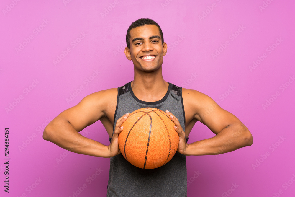 Young sport man with ball of basketball over isolated purple wall Young sport man with ball of basketball over isolated purple wall