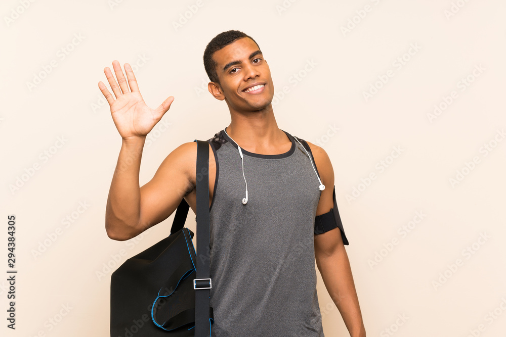 Sport man over isolated background saluting with hand with happy expression Sport man over isolated background saluting with hand with happy expression