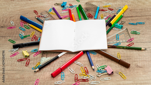 Marker and notebook on wood background.