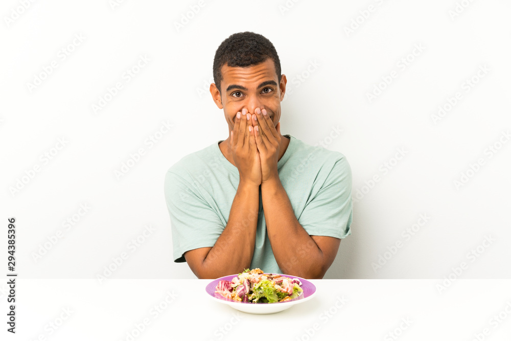 Young handsome man with salad in a table with surprise facial expression Young handsome man with salad in a table with surprise facial expression