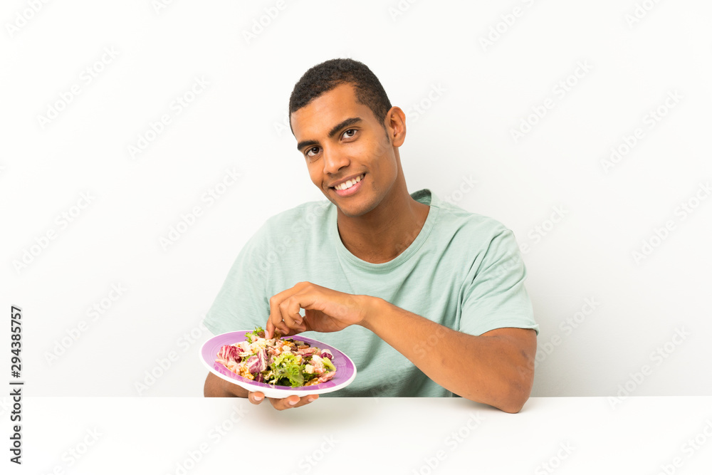 Young handsome man with salad in a table Young handsome man with salad in a table