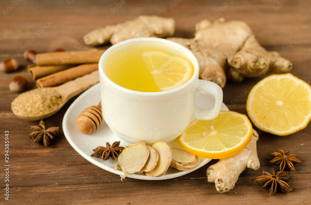 Ginger tea with lemon in a white cup on a wooden table Ginger tea with lemon in a white cup on a wooden table