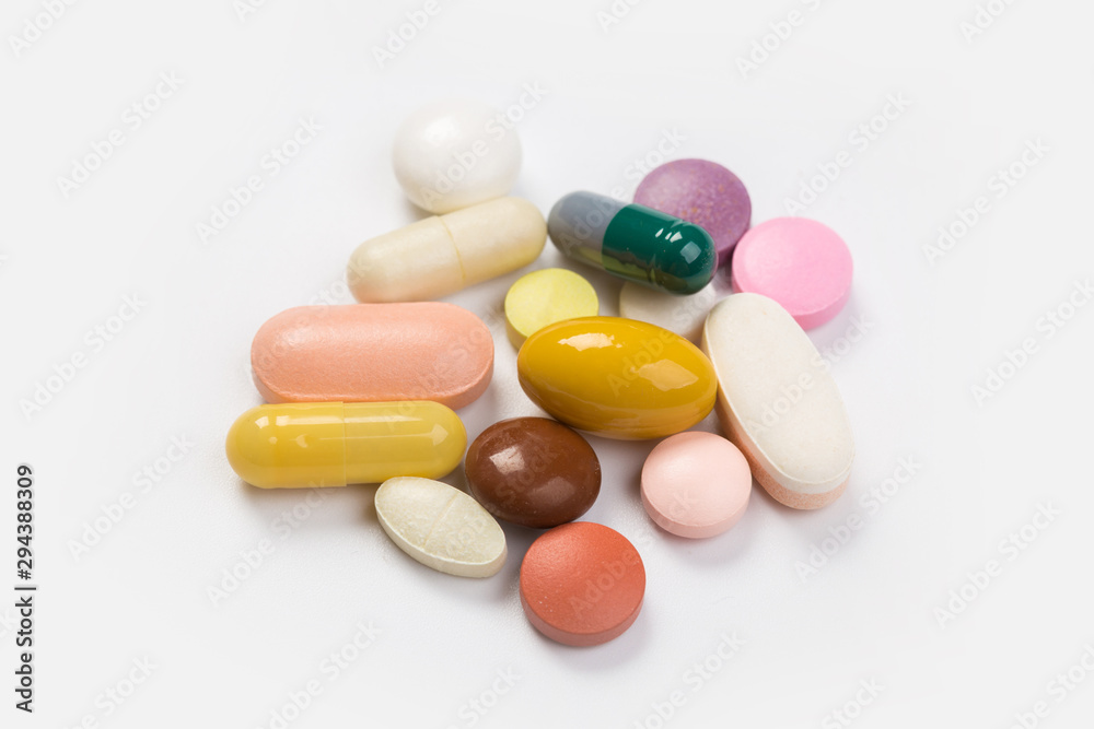 Assorted pharmaceutical medicine pills, tablets and capsules.Heap of assorted various medicine tablets and pills different colors on white background. Top view.Copy space