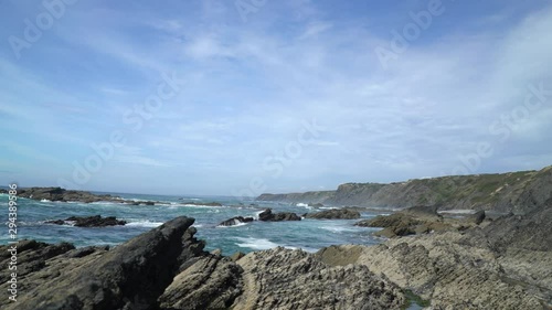 Reveal shot of a natural rocky wild coast beach with beautiful waves ocean