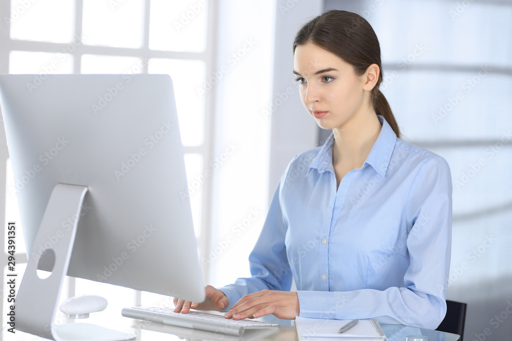 Business woman working with computer at the glass desk in modern office. Student girl preparing presentation or bookkeeper making balance. Tax and audit concept Business woman working with computer at the glass desk in modern office. Student girl preparing presentation or bookkeeper making balance. Tax and audit concept