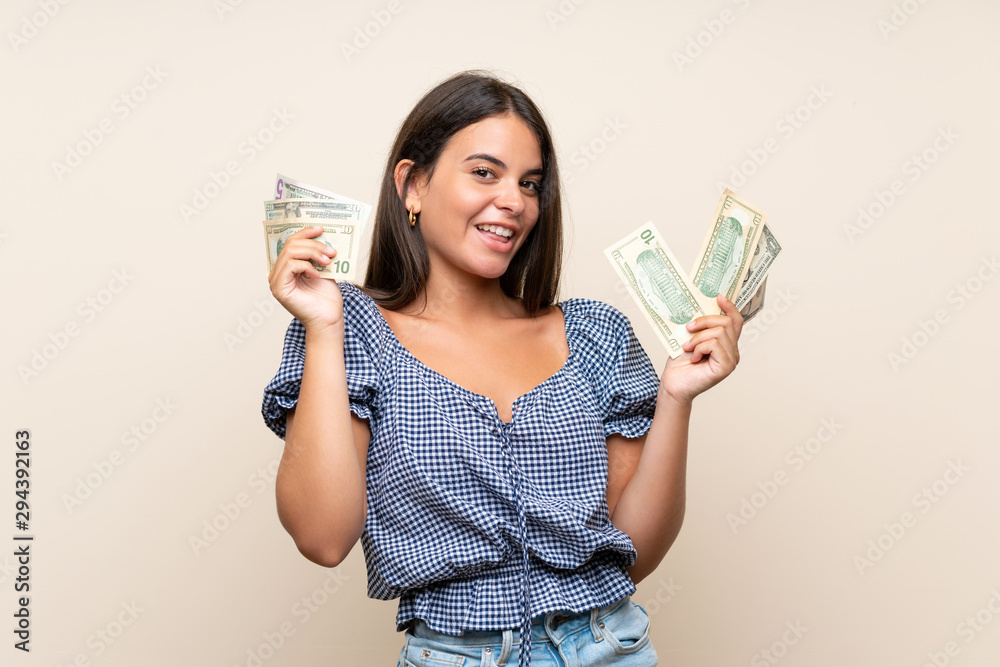 Young girl over isolated background taking a lot of money Young girl over isolated background taking a lot of money