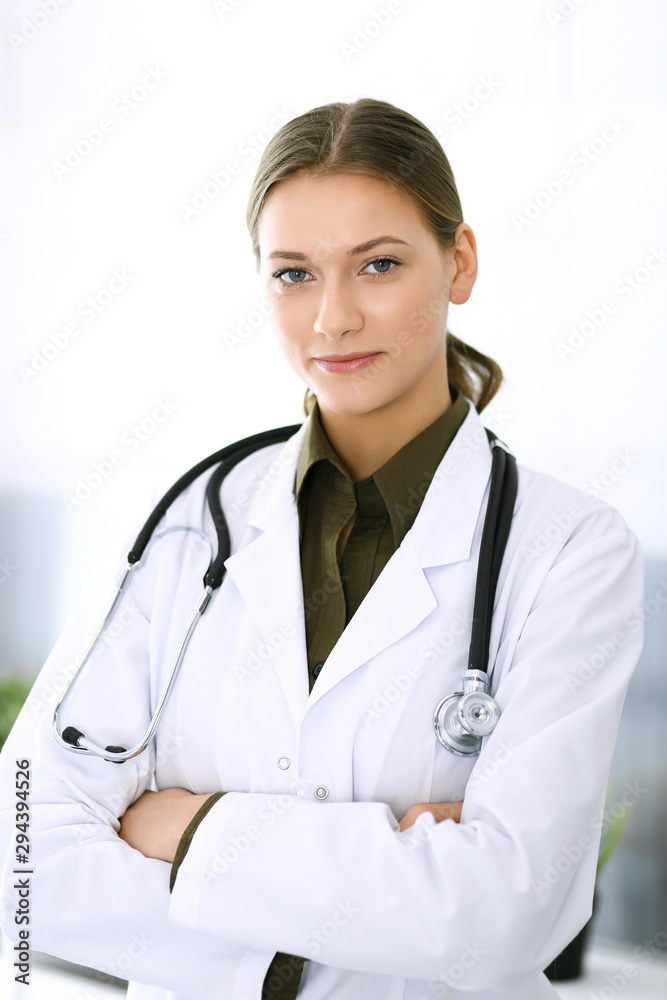 Doctor woman standing straight and looking at camera. Perfect medical service in clinic. Happy future in medicine and healthcare Doctor woman standing straight and looking at camera. Perfect medical service in clinic. Happy future in medicine and healthcare