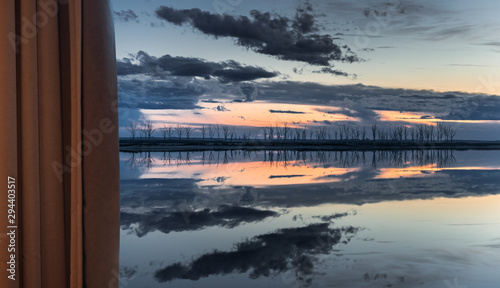 Lake and sunset through the curtains. © nickalbi