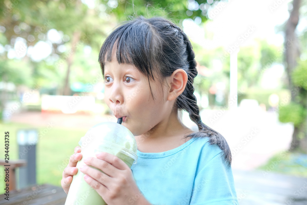 Girls enjoy sucking green tea drinks. Girls enjoy sucking green tea drinks.