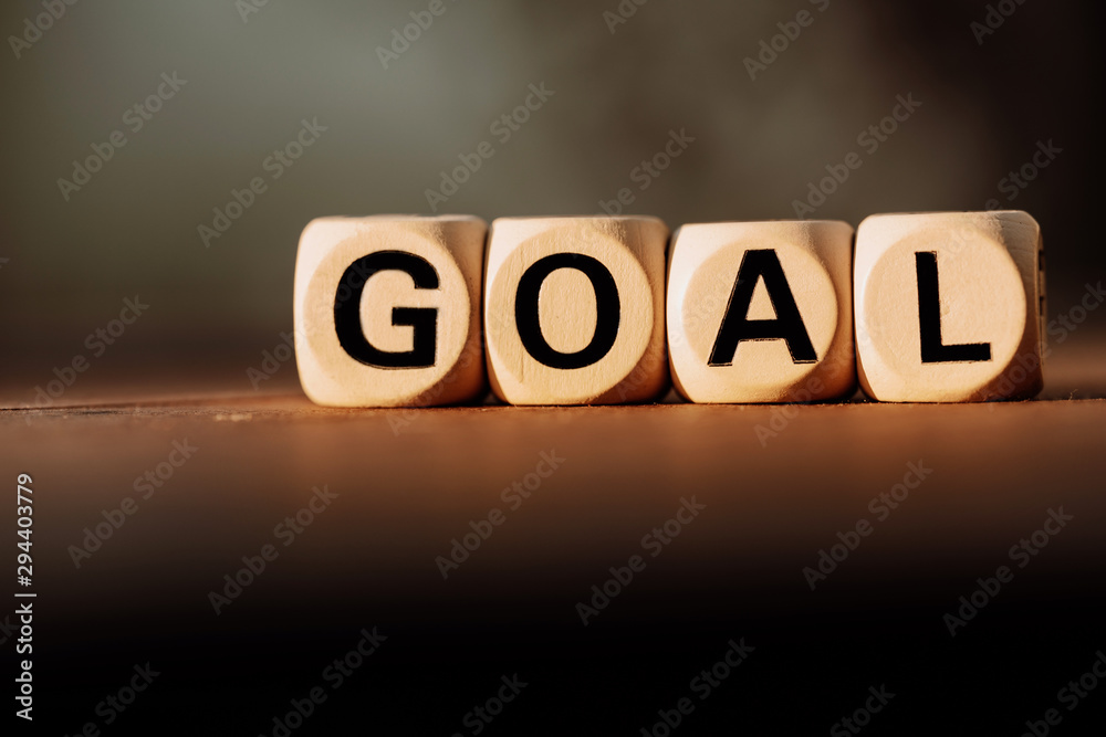 Obraz premium Block wood with GOAL on abstract blurred backgroune. Business goal word concept.
