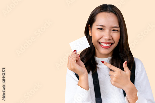 close up caucasian woman hand holding and pointing on blank white mockup business card isolated over  cream color background for special offer promotion and design marketing content in winter season  photo
