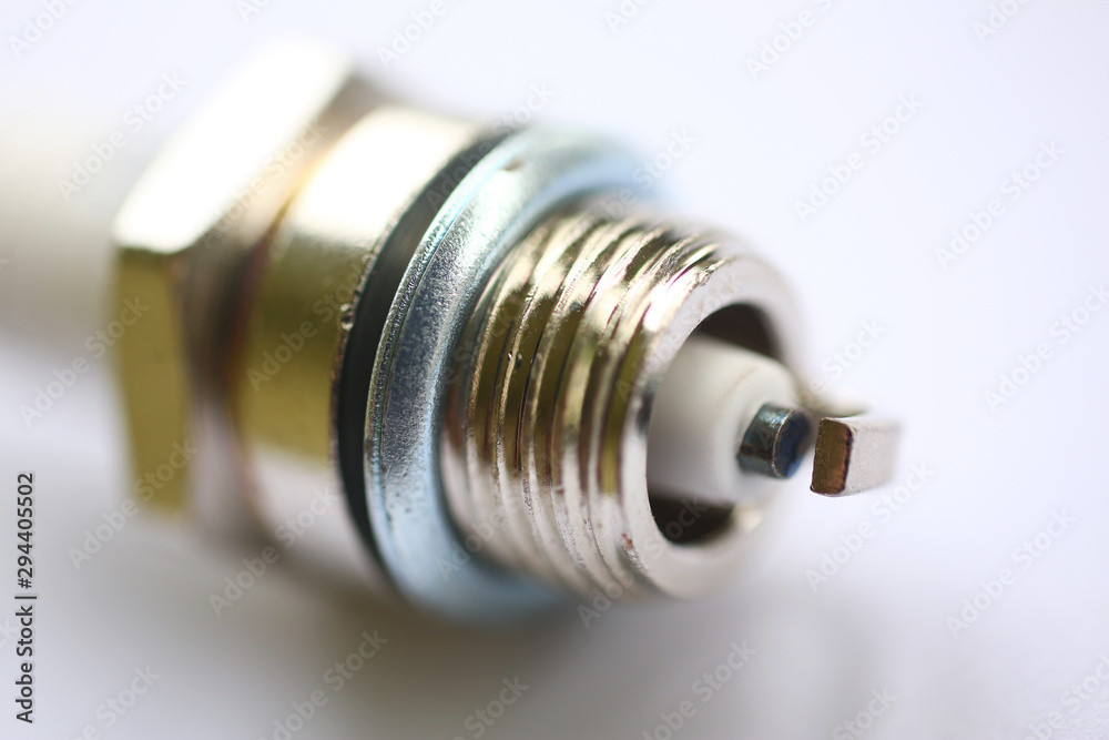 Focus on lamp base lying on white table workplace with highly-detailed parts of construction. Fluorescent tube of energy saving compact light bulb. Blurred background Focus on lamp base lying on white table workplace with highly-detailed parts of construction. Fluorescent tube of energy saving compact light bulb. Blurred background
