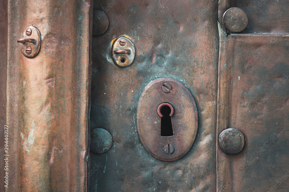 Fototapeta premium Old copper door with key hole and rivets