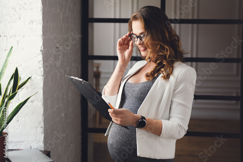 Pregnant mature businesswoman working at office