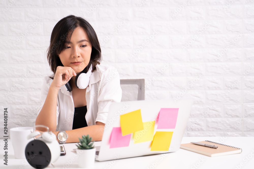 Thoughtful woman sitting at home office working using computer laptop Thoughtful woman sitting at home office working using computer laptop