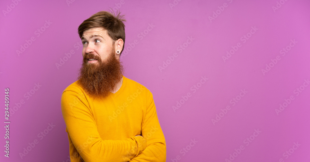 Redhead man with long beard over isolated purple background with arms crossed and happy Redhead man with long beard over isolated purple background with arms crossed and happy