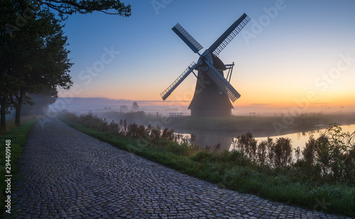 Windmill during a foggy, autumn sunrise in the Dutch countryside. Krimstermolen, Zuidwolde.