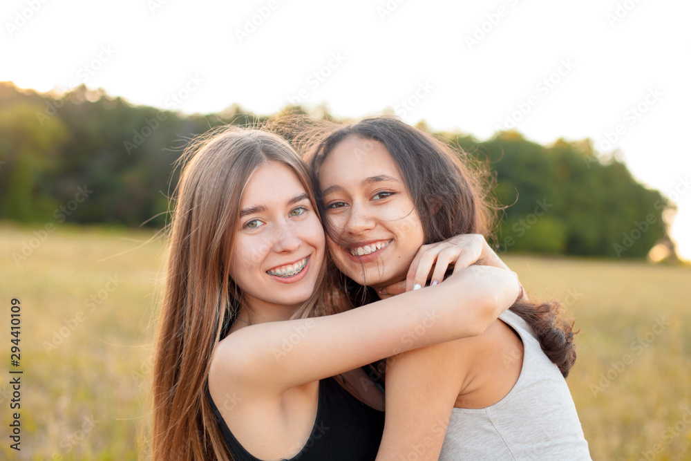 Two beautiful young women hugging outdoors, Best friends
