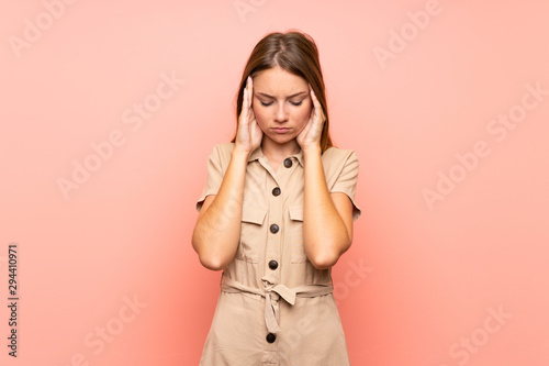 Lithuanian blonde girl over isolated pink background with headache