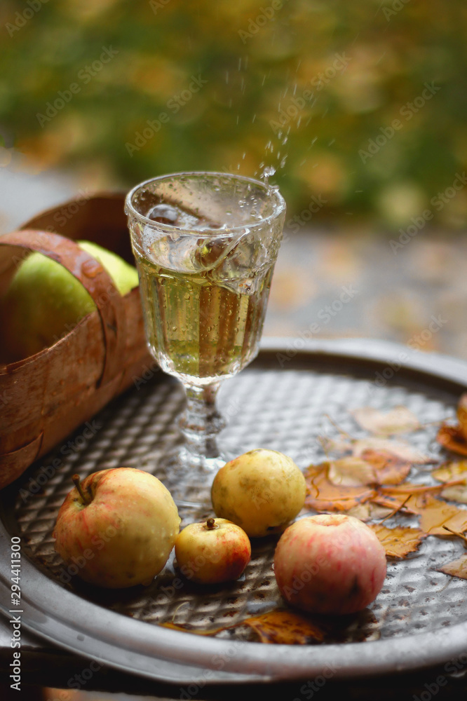 A glass of juice on a tray in the rain, splashing A glass of juice on a tray in the rain, splashing
