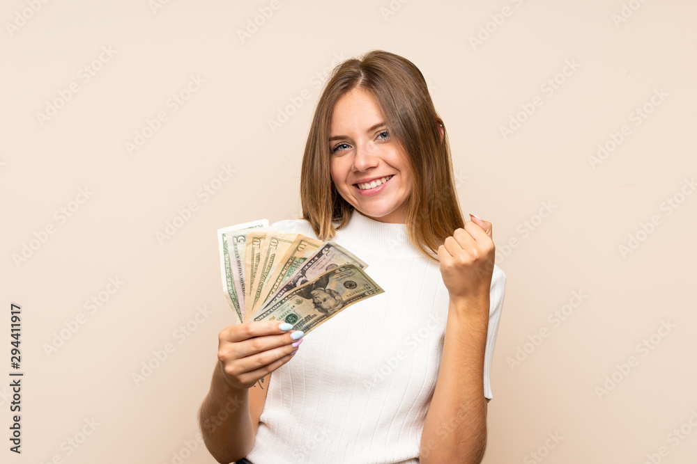 Young blonde woman over isolated background taking a lot of money Young blonde woman over isolated background taking a lot of money