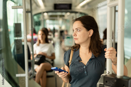 Woman using mobile phone in the cabin of a bus or tram