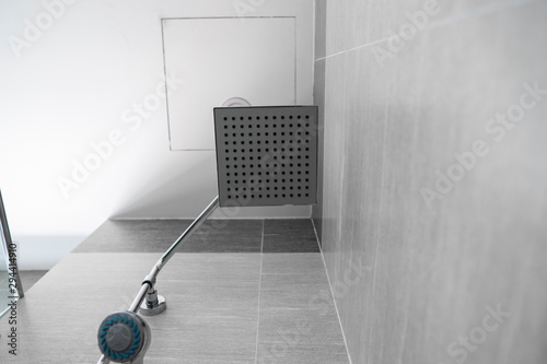 Square shower head and classic shower head in a modern bathroom. Shower in the bathroom with water spray or water. A stream of fresh water from the shower head to clean the dirty body.