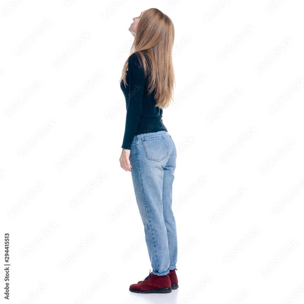 Woman in jeans and sweater looking standing on white background isolation, rear view Woman in jeans and sweater looking standing on white background isolation, rear view