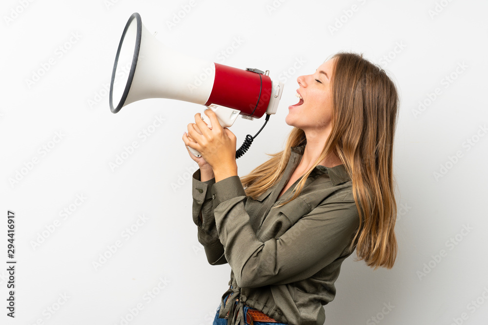 Lithuanian blonde girl over isolated white background shouting through a megaphone Lithuanian blonde girl over isolated white background shouting through a megaphone