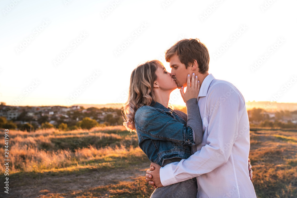 Loving couple is about kiss at sunset. Loving couple is about kiss at sunset.