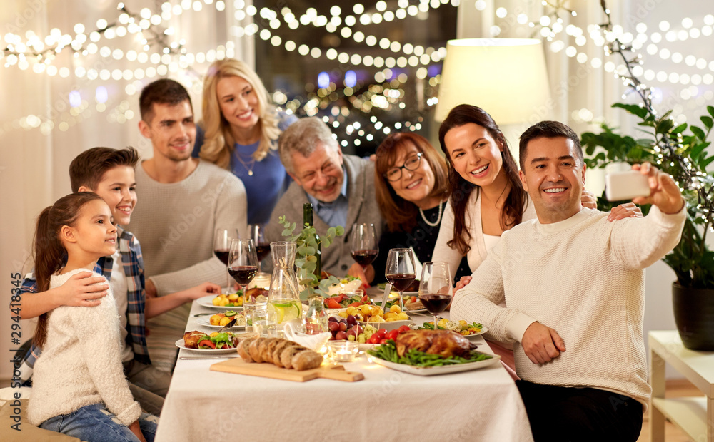 celebration, holidays and people concept - happy family having dinner party at home and taking selfie by smartphone