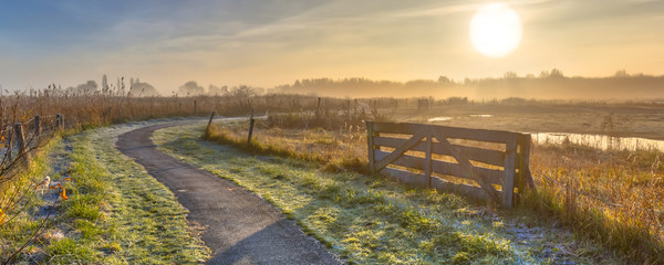 Gate in misty agricultural landscape
