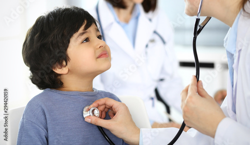 Doctor examining a child patient by stethoscope. Cute arab boy at physician appointment. Medicine and healthcare concept