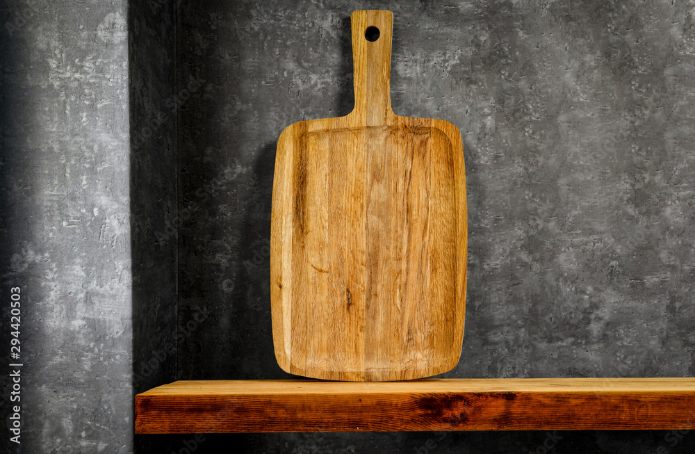 Wooden brown kitchen shelf with free space for your decoration and dark gray retro wall. 