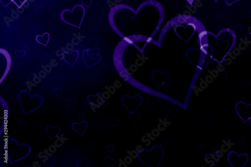 Purple hearts on black background. Valentine's Day abstract background with hearts