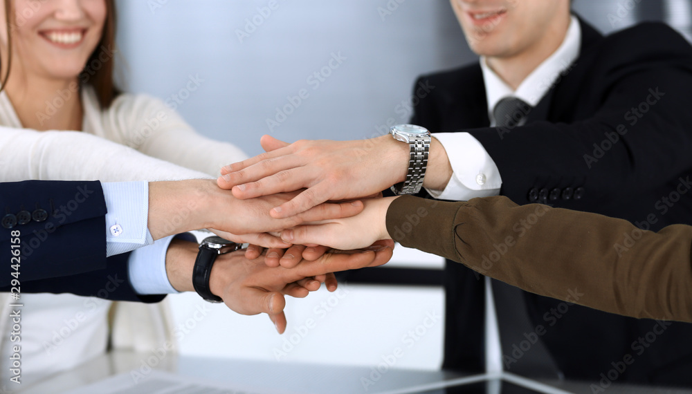 Business people group showing teamwork and joining hands or giving five after signing contract in modern office. Unknown businessman and woman with colleagues or lawyers making circle with their hands