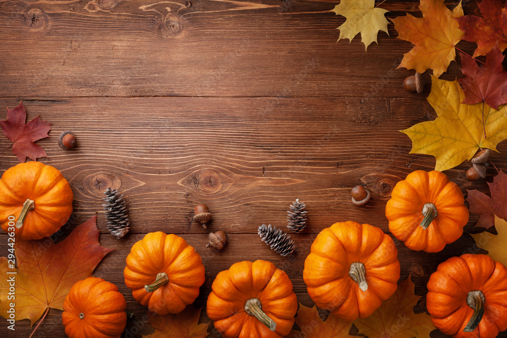 Autumn Thanksgiving background. Pumpkins, acorns and leaves on rustic wooden table top view. - obrazy, fototapety, plakaty 
