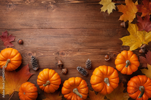 Autumn Thanksgiving background. Pumpkins  acorns and leaves on rustic wooden table top view.