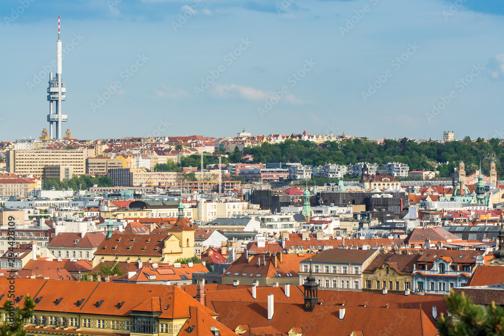 Aerial view of citycape of old town of Prague, with a lot of  rooftops, churches, and the landmark of Television Tower. view from the Letna park.