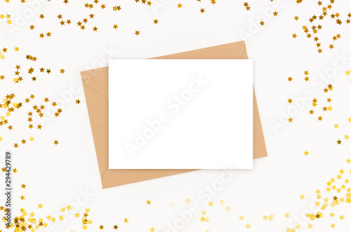 Empty greeting card with a paper craft envelope and gold confetti. Mockup template with copy space for calligraphy lettering