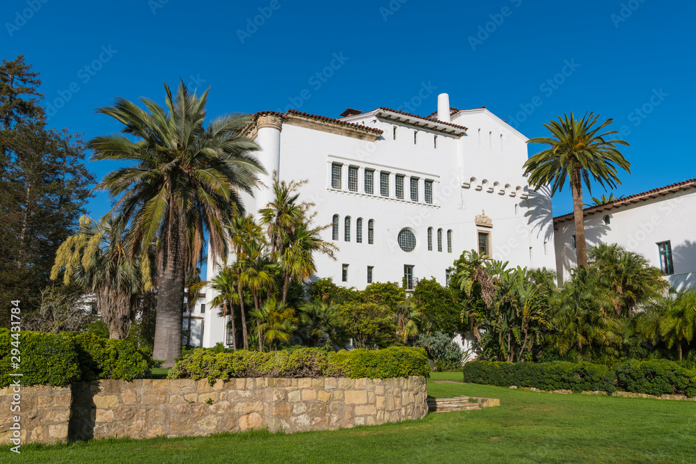 Historic white Spanish colonial revival architecture building in beautiful tropical gardens under a perfect blue sky